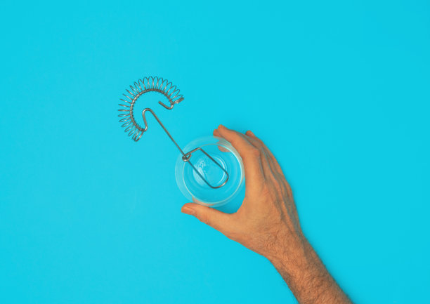 男性手拿着一个杯子，里面有奶油打蛋器图片下载