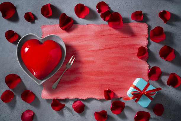 情人节红心形蛋糕和红玫瑰花瓣上的灰色图片下载