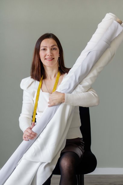 女时装设计师拿着一卷一卷的婚纱面料图片下载