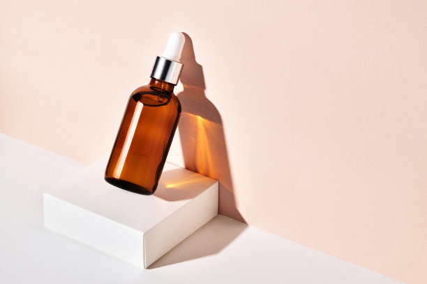 在白色的底座上装有芳香油或血清的玻璃瓶。图片下载