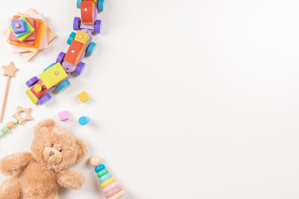 婴儿玩具框架上的白色背景。泰迪熊和许多多彩的蒙特梭利教育木制玩具。俯视图，平躺图片下载