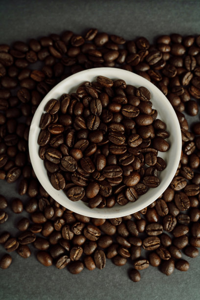 一碗咖啡豆堆在一堆咖啡豆里图片下载