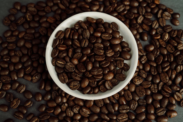 一碗咖啡豆堆在一堆咖啡豆里图片下载