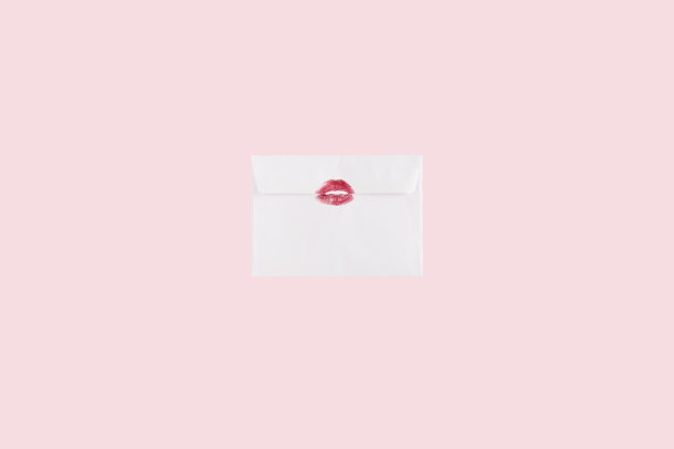 粉红色背景上亲吻的信封。最小的爱的概念。平的。红色吻的象征。图片下载