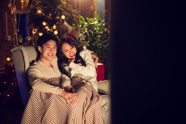 幸福甜蜜的年轻夫妇坐在沙发上图片下载