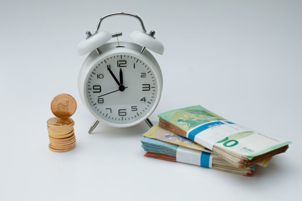 闹钟旁边放着一堆金币图片下载