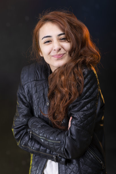 身穿外套的红头发年轻女孩对着镜头微笑。图片下载