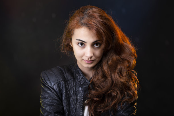 穿着外套的红头发年轻女孩正看着镜头。图片下载