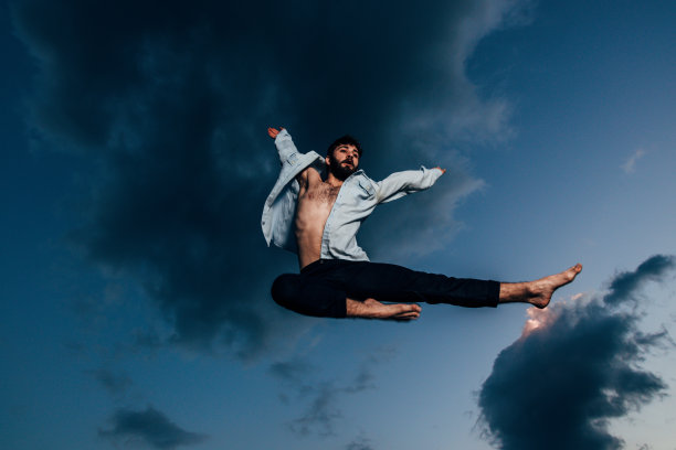 穿着t恤在空中跳跃的运动舞者图片下载