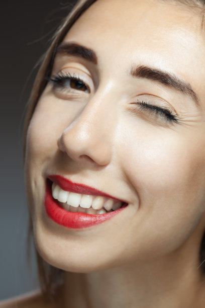 美丽的黑发女孩工作室肖像。眨眼和微笑的表情。图片下载