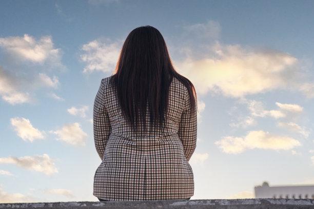 一个黑发长发女孩的后视图。女商人从繁忙的生活中抽出时间休息和思考。平静的概念图片下载