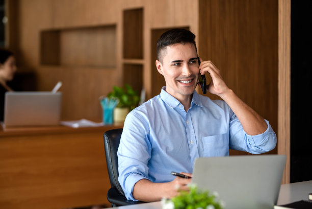 快乐的商人在办公室用手机交流。图片下载