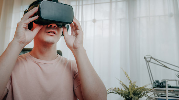 男子使用虚拟现实眼镜头戴旅行在元宇宙数字网络世界在家里图片下载