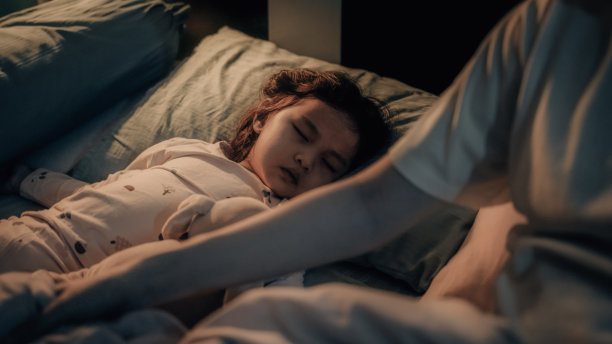 亚洲婴儿或女孩晚上和她的母亲睡在卧室里。她玩了一整天，累了图片下载