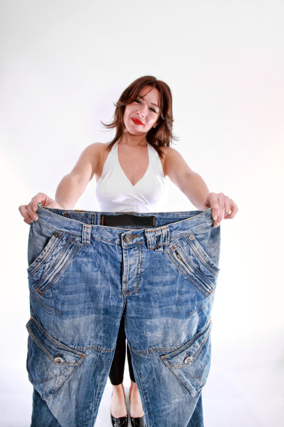 年轻女性展示大牛仔裤的节食概念图片下载