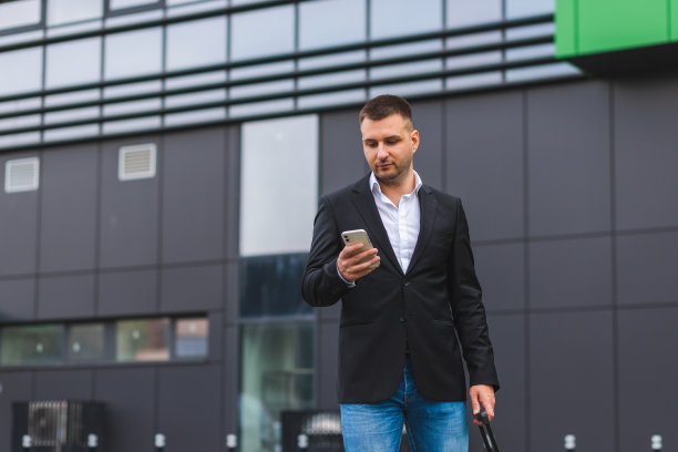 一名年轻商人在城市环境中使用智能手机的半身照片图片下载
