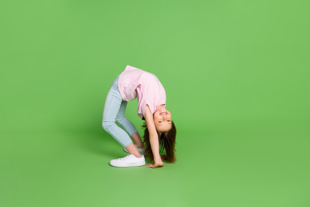 完整的小女孩侧面照片快乐积极的微笑站桥姿势运动孤立在绿色的背景图片下载