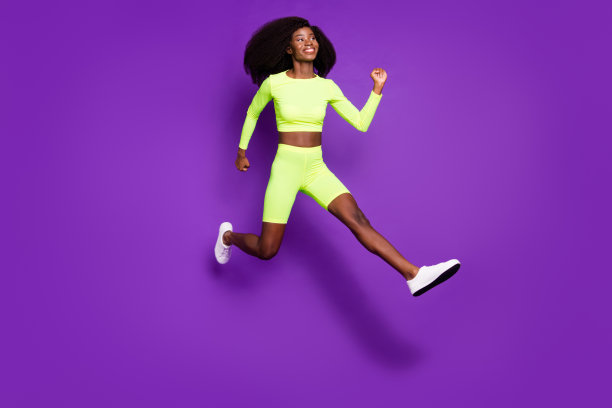 头像照片活跃的年轻女士跳跑空空间穿绿色衬衫短裤鞋孤立的紫色背景图片下载
