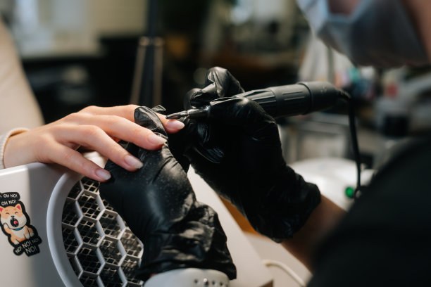 特写镜头，无法辨认的女美甲师去除凝胶polish或丙烯酸从指甲与美甲机的帮助。图片下载