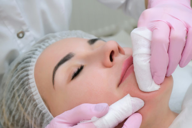美容。可爱的年轻女子闭着眼睛接受面部清洁程序的特写照片图片下载