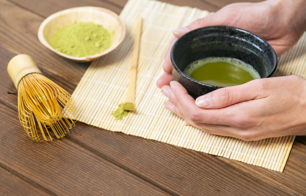 女孩的手握着日本传统抹茶碗中的抹茶，用竹勺、打蛋器和抹茶粉图片下载