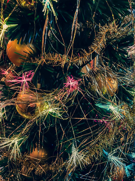 圣诞树的树枝上装饰着金球，闪闪发光。图片下载