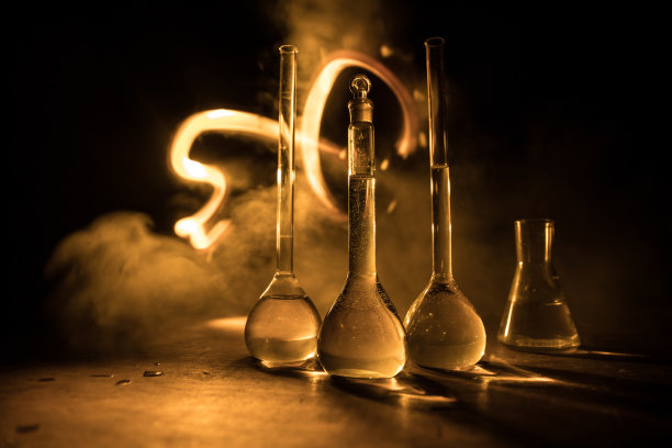 在实验室用溶液测试玻璃烧瓶。科学和医学背景。实验室试管暗色调背景，科研设备概念图片下载