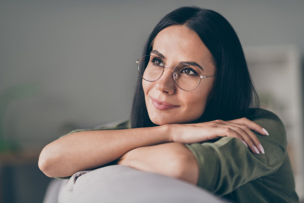 年轻漂亮的女人快乐的照片积极微笑戴眼镜梦想梦幻的样子空空间沙发家图片下载