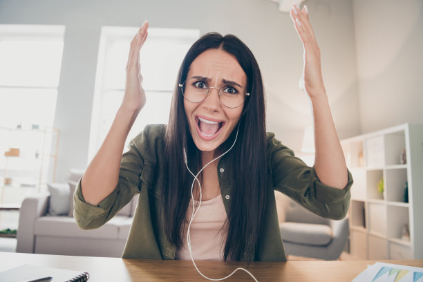 年轻的照片生气的愤怒的不高兴的不安的紧张的坏心情女人戴着眼镜和耳机在家里视频电话吵架图片下载