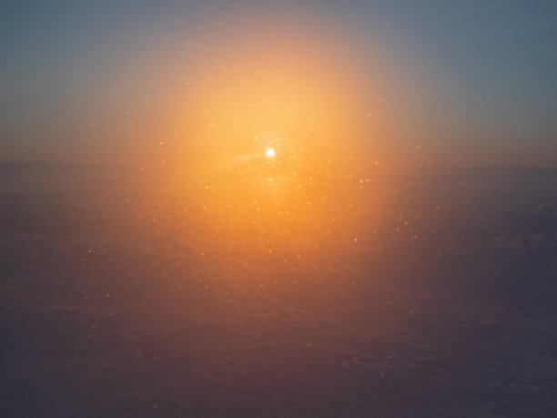 散焦的彩色背景，冬天冰冻的窗户，透过它极地的太阳升起。图片下载