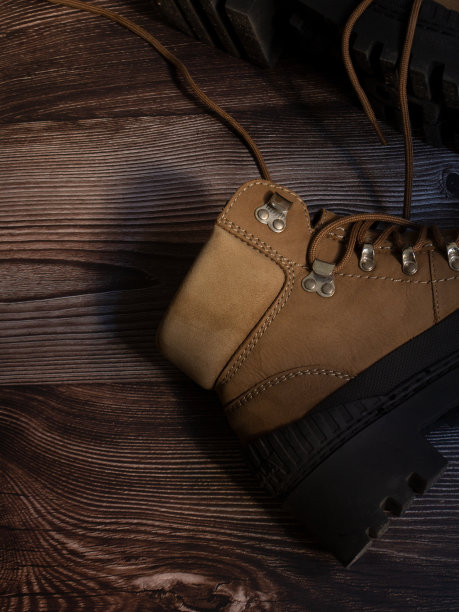 女人的登山靴在深色的木头上图片下载