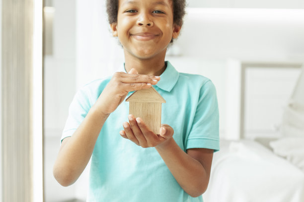 微笑的非洲裔美国小孩手中的生态木屋图片下载