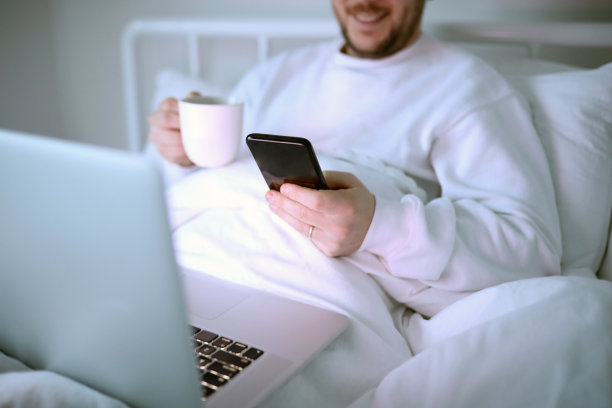 床上的咖啡，电脑和电话的概念图片下载