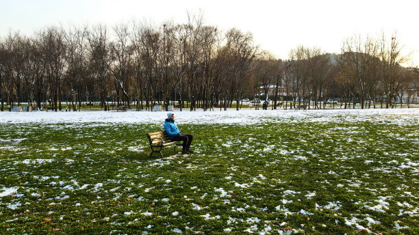 孤独的人坐在长椅上，在冬天的日子里坐在长椅上，孤独的人，悲伤和思考的人，在寒冷中等待的人，图片下载