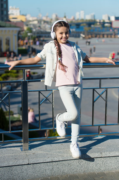 令人兴奋的城市和博物馆之旅。城市导游和音频导游。小女孩旅游儿童使用音频导游手机应用程序。音频游览耳机小工具。自由出行图片下载