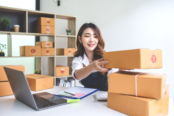 一名妇女在家工作，在线投递包裹。中小企业配送理念与包装图片下载