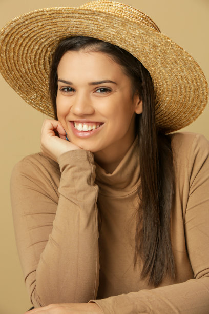 美丽的年轻黑发女子的肖像米色高领毛衣和草帽图片下载