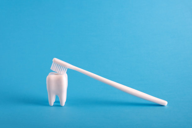 白色的人类牙齿模型和蓝色的医学背景牙刷。牙科保健基本医疗海报。图片下载