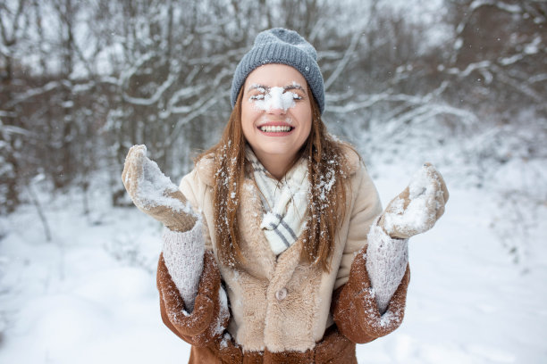 一幅年轻女子在雪山上享受冬天的肖像图片下载