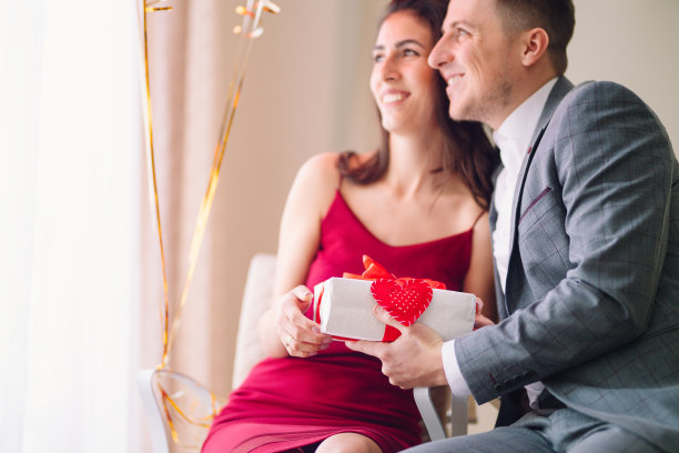 交换礼物。美丽的年轻情侣在餐厅庆祝情人节图片下载