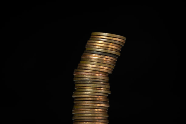 倾斜堆栈的硬币与黑色的背景图片下载