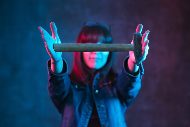 在黑暗的背景上有彩色灯光的年轻女子。图片下载