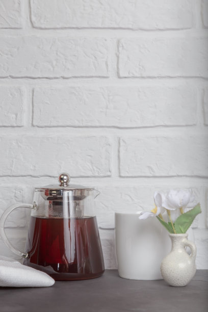 厨房舒适的灯光背景与复印空间在阁楼风格。桌子上有一个带茶的玻璃茶壶。茶歇时间图片下载