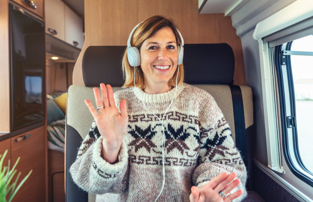 一个快乐的女人在她的露营车里对着视频电话挥手图片下载