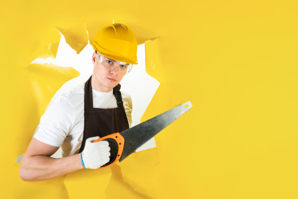穿制服的专家正在用锯子工作图片下载