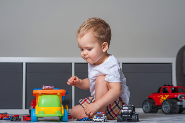 蹒跚学步的男孩在游戏室里玩教育玩具……图片下载