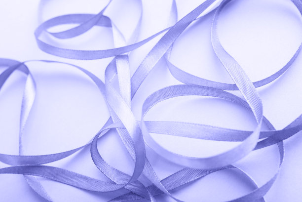 紫色背景上弯曲的紫色金丝带。特写镜头。时尚的颜色。颜色2022。今年的流行色非常佩里。图片下载