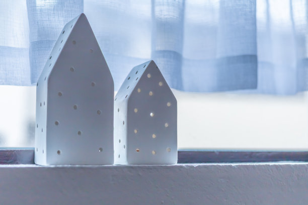 窗台上有两个白色的微型装饰房子。图片下载