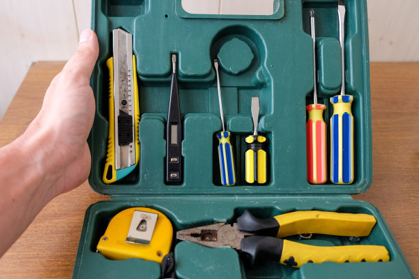 男人手打开旧式绿色方形工具箱，内有家用维修手动工具。俯视角度图片下载