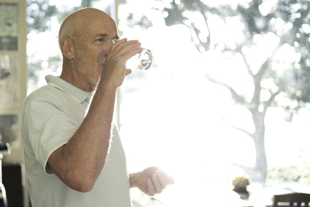 老年男性每天用一杯水服用药物图片下载